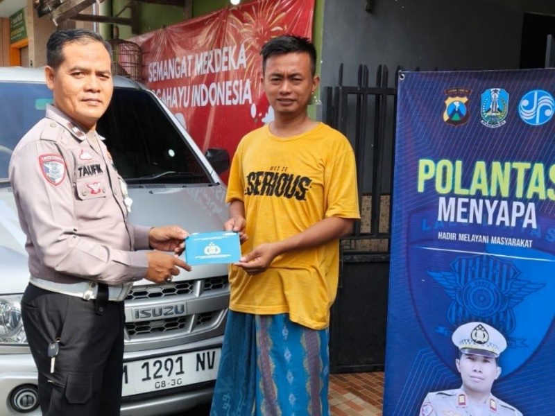 Anggota Satlantas Polres Sampang Aipda Taufik Hidayat saat mengantarkan BPKB kepada masyarakat.